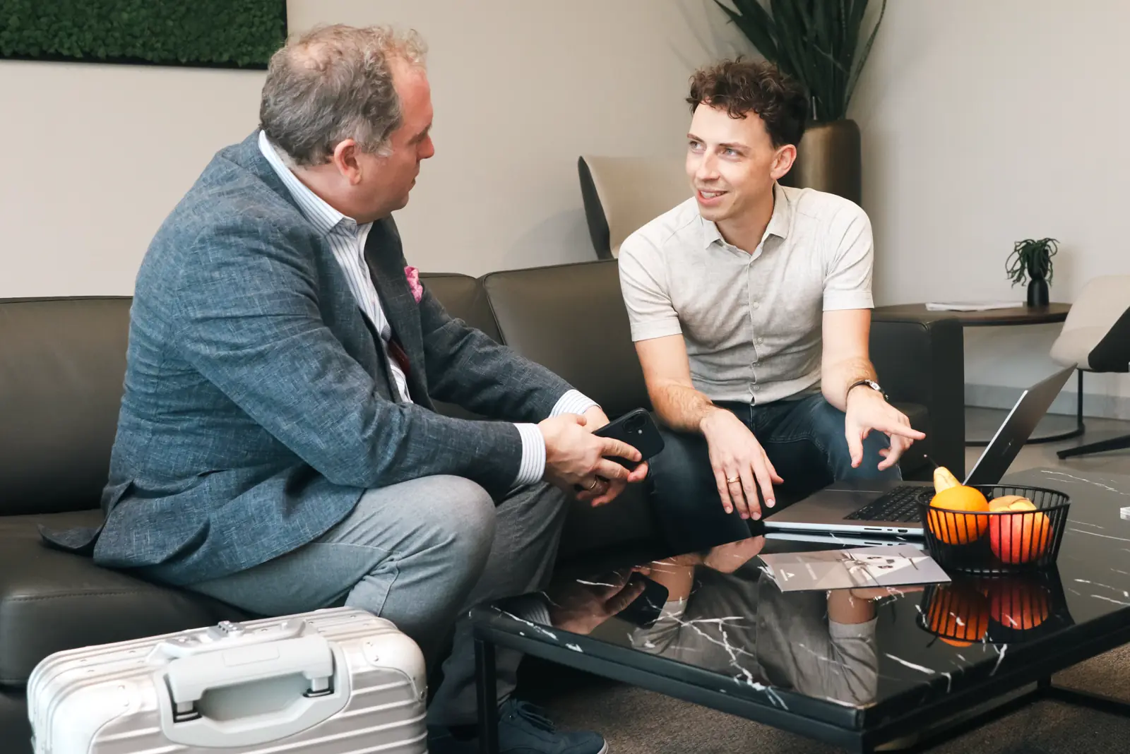 Thorsten Neumann und Christian Haselsberger in der Lounge am Laptop und mit Handy